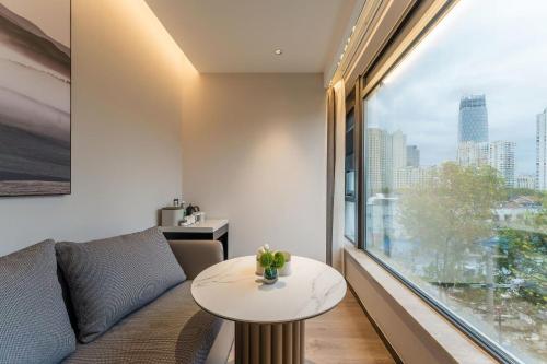 a living room with a table and a large window at Atour Hotel ShanghaiPeople's Square Xintiandisubway - FreeMini Bar and Free NightSnacks in Shanghai
