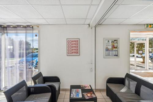 a waiting room with two chairs and a table at Hôtel AKENA Chateaurenard - Parc des Expositions Avignon in Châteaurenard