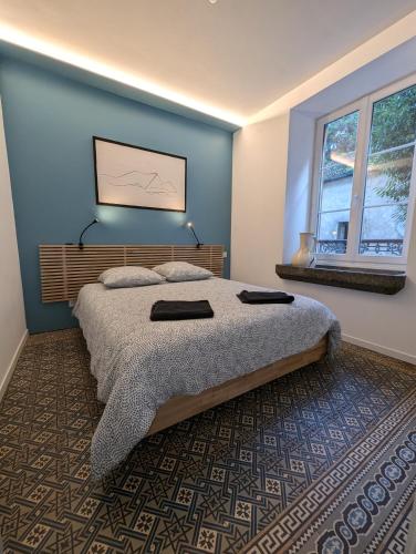 une chambre avec un lit et un mur bleu dans l'établissement Petite perle Maison de Maître, à Sainte-Marie-aux-Mines