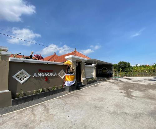 a building with a sign on the side of it at Penginapan angsoka 2 in Singaraja