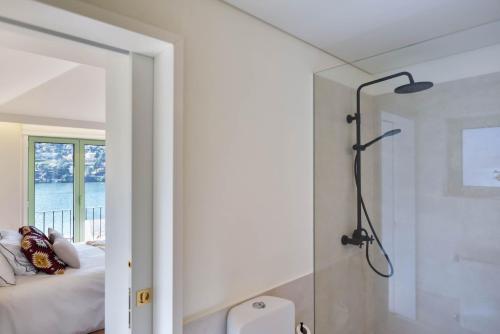a bathroom with a shower next to a bed at Feel Discovery Casa de Cima Douro Valley in Riba Douro