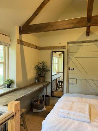 a bedroom with a bed and a barn door at Victorian Red Brick Barn in the Heart of Stamford in Lincolnshire