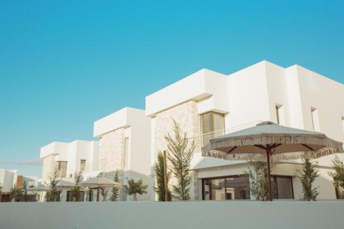 a rendering of a building with an umbrella at LIV & CO Suites & Villas in Voroklini