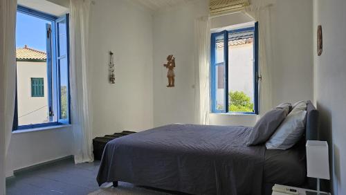 a bedroom with a bed and two windows at Sea House in Galaxidi