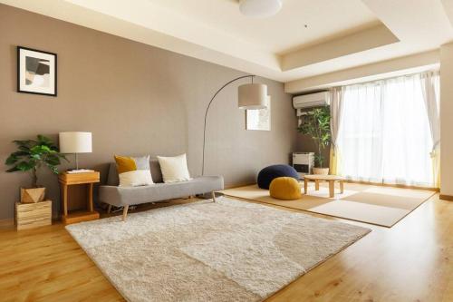 a living room with a couch and a rug at Cozy Stay Sapporo Central 1504 in Toyohira