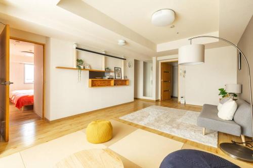 a living room with a couch and a chair at Cozy Stay Sapporo Central 1504 in Toyohira
