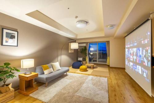 a living room with a couch and a projection screen at Cozy Stay Sapporo Central 1504 in Toyohira