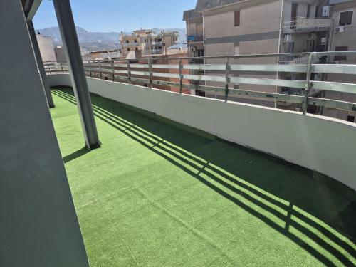 a balcony with green grass on the side of a building at Attico Solaris in Reggio Calabria