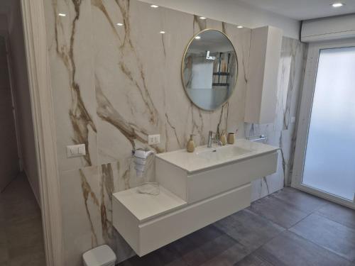 a bathroom with a white sink and a mirror at Attico Solaris in Reggio Calabria