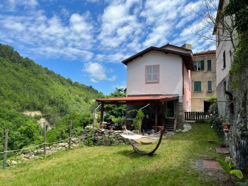 a house with a bench in front of a yard at Casa Camerana 16 personnes in Camerana 