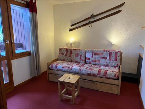 - une petite chambre avec un lit et une table en bois dans l'établissement Studio divisible chaleureux proche des pistes avec balcon - FR-1-181-2535, à La Plagne Tarentaise