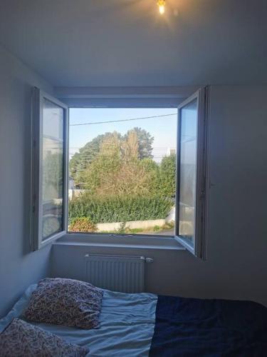 un lit dans une chambre avec une grande fenêtre dans l'établissement Studio à Clis, à Guérande