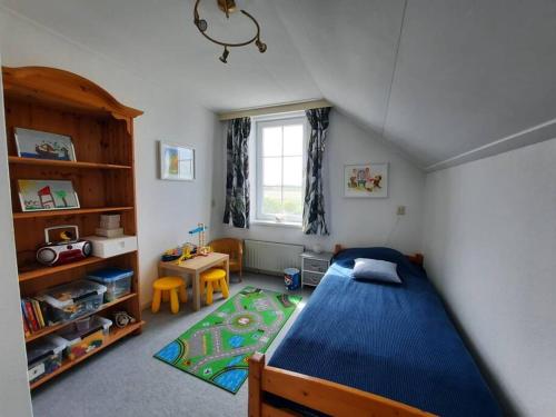 ein Schlafzimmer mit einem blauen Bett und einem Tisch in der Unterkunft Lamsoor 20 in Nieuwvliet