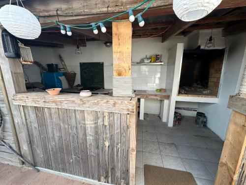 un bar extérieur avec une clôture en bois et des lumières dans l'établissement La Villa Au Bord du Canal, à Frontignan