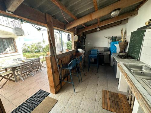 une cuisine avec un comptoir, une table et des chaises dans l'établissement La Villa Au Bord du Canal, à Frontignan
