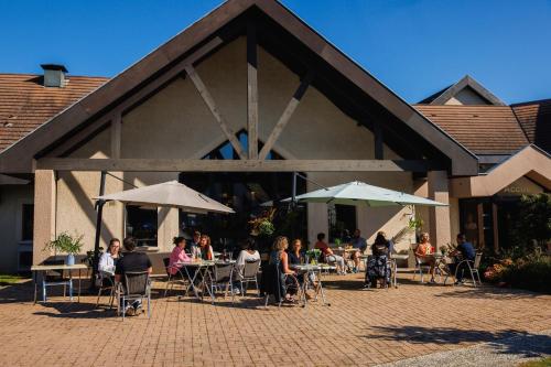 a group of people sitting at tables in front of a building at Mont Vernon in Saint-Marcel