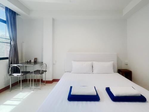 a bedroom with a white bed with blue pillows on it at Vonden Garden by Merry V in Bangkok
