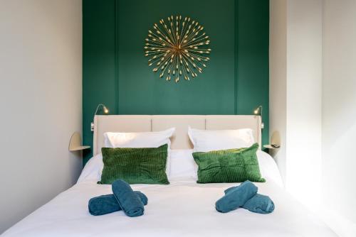 une chambre avec un lit blanc avec des oreillers bleus dans l'établissement Le Muxu, à Toulouse