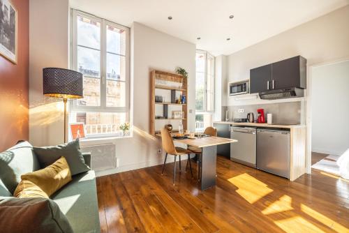 une cuisine et un salon avec une table et un canapé dans l'établissement Le Muxu, à Toulouse