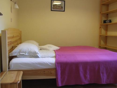 a bedroom with a bed with a purple blanket on it at Pokoje i apartamenty pod Jaworzyną w Koninkach in Koninki