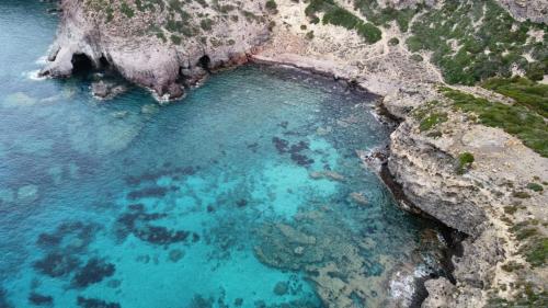 an aerial view of a pool of blue water at Agriturismo Glamping Erbe Matte in SantʼAntìoco