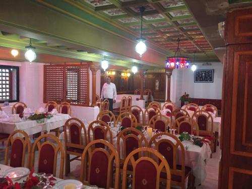 a man standing in a room with tables and chairs at Hotel La Residence Hammamet in Hammamet