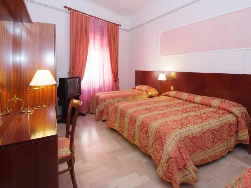 レカナーティにあるHotel Ristorante La Ginestraのベッド2台とテレビが備わるホテルルームです。