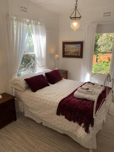 a bedroom with a large bed and a window at Historic Corinda Cottage in Bundanoon