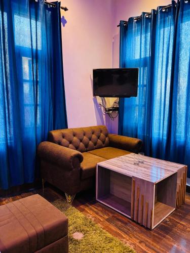 a living room with a couch and a table at Himalayan Canvas khajjiar in Khajjiar 