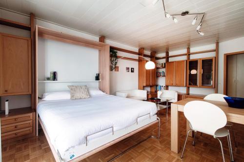 a bedroom with a bed and a dining room at Francobollo Studio by Quokka 360 - flat with balcony in Massagno