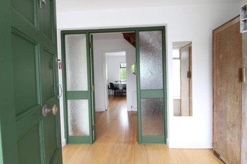 a hallway with green doors in a room at THE VILLAGE HOUSE on Wild Atlantic Way CLARINBRIDGE VILLAGE in Galway