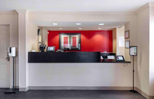 a cashier counter with a red wall at Extended Stay America Select Suites - Dallas - Farmers Branch in Farmers Branch
