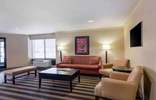 a living room with a couch and a table at Extended Stay America Select Suites - Dallas - Farmers Branch in Farmers Branch