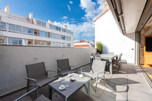 un balcon avec des tables et des chaises et un bâtiment dans l'établissement DUPLEX 145m Private Terrace and Elevator, à Cannes