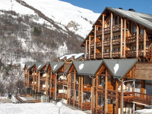 un lodge dans la neige avec des montagnes enneigées dans l'établissement Studio confort 2 pers. avec piscine, sauna et parking à Valloire - FR-1-263-483, à Valloire