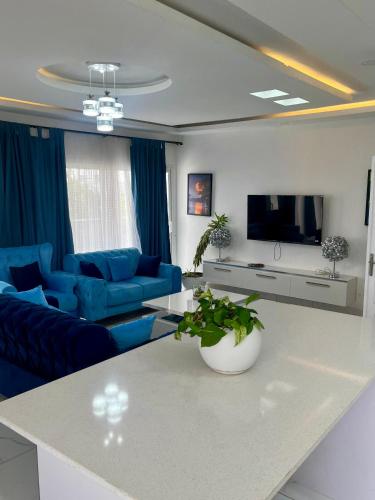 a living room with a blue couch and a table at Résidence Turpin in Toubab Dialaw
