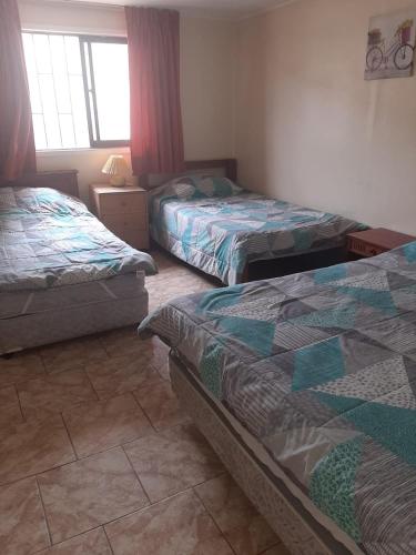 una camera da letto con due letti e una finestra di Linda casa con piscina en el quisco. a El Quisco