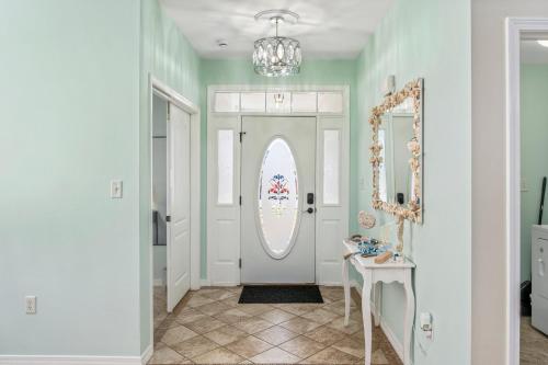 a hallway with a white door and a table and mirror at Beautiful Pet Friendly Home! Tropical Pool, Optional Golf Cart & Pool Heat, Minutes to Beach in Destin