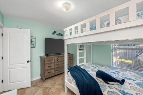 a bedroom with a bunk bed and a tv at Beautiful Pet Friendly Home! Tropical Pool, Optional Golf Cart & Pool Heat, Minutes to Beach in Destin