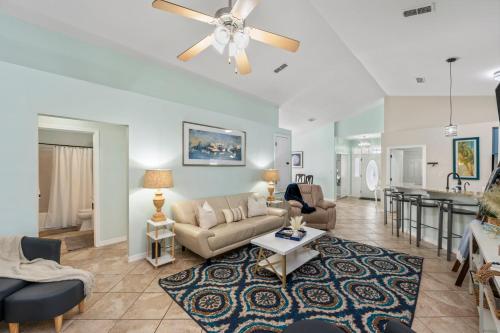 a living room with a couch and a table at Beautiful Pet Friendly Home! Tropical Pool, Optional Golf Cart & Pool Heat, Minutes to Beach in Destin