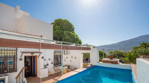 a villa with a swimming pool next to a house at Huerta La Niña Arenas Órgiva by Ruralidays in Órgiva