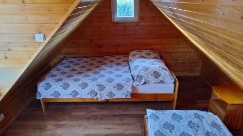 a bed in the attic of a log cabin at Tajek in Stegna