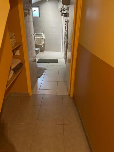 La salle de bains est pourvue de toilettes et de carrelage. dans l'établissement Appartement moderne à La Ferrière-aux-Étangs de 55 m² avec jacuzzi, à La Ferrière-aux-Étangs