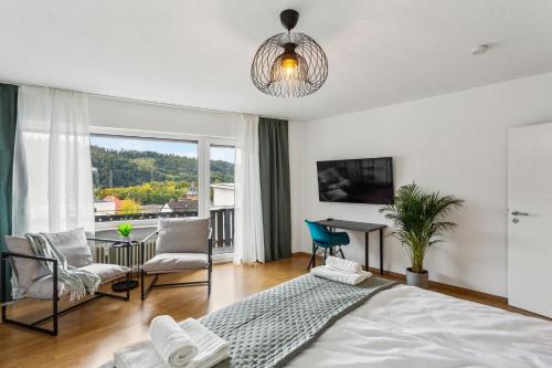 une chambre avec un lit, une table et des chaises dans l'établissement DDHomes LahnLiebe App 01 - Balkon,Therme,SmartTV, à Bad Ems