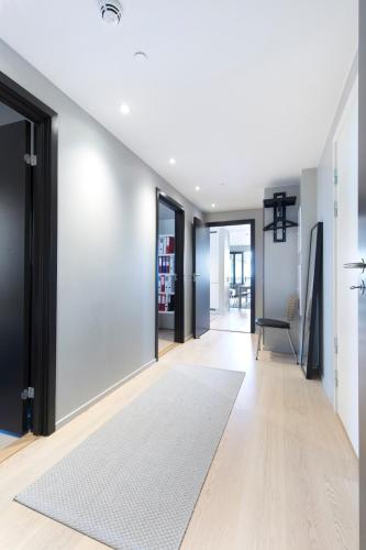 an open hallway with a white rug and sliding glass doors at Super Central Designer Penthouse at 19th floor with Amazing View! in Oslo