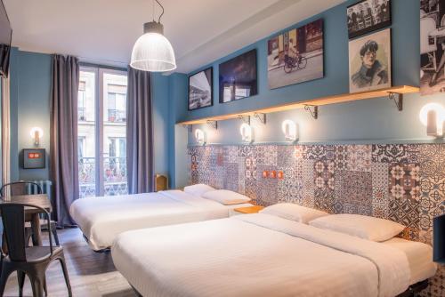 a row of beds in a hotel room at Hôtel de Roubaix in Paris