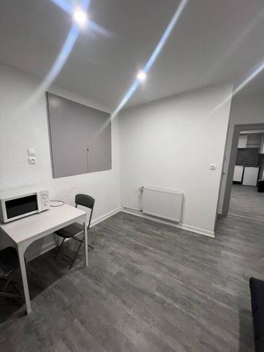 une pièce vide avec un bureau blanc et une table dans l'établissement Studio du Japon, à Montbéliard
