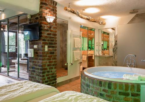 a large bathroom with a large tub in a room at Hotel Land Gut Höhne in Mettmann