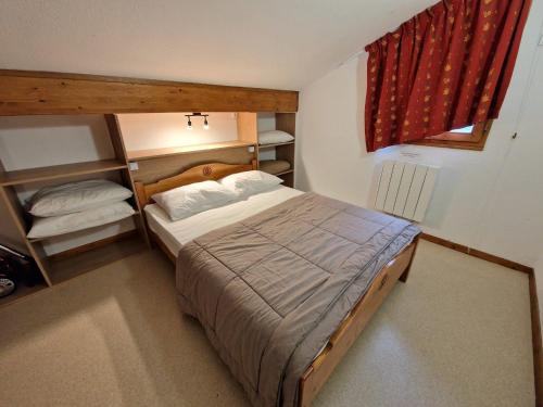 - une petite chambre avec un lit et un rideau rouge dans l'établissement Joli duplex spacieux 10/12 personnes - FR-1-265-174, à Valfréjus