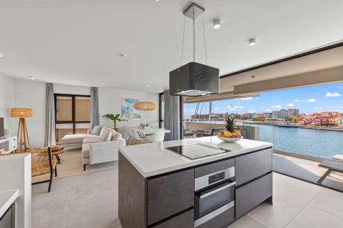 una cucina e un soggiorno con vista sull'acqua di The Wharf 7E city apartment, overlooking Annabay, downtown Willemstad a Willemstad